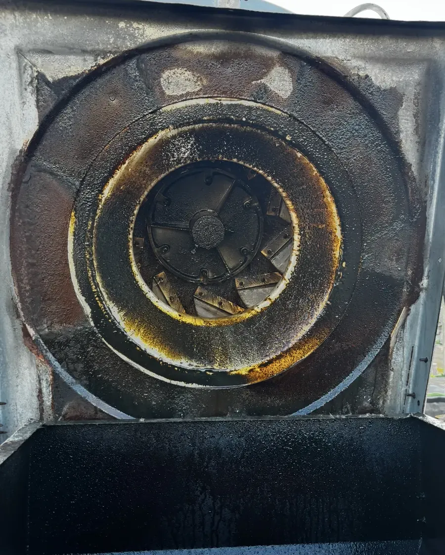 Rooftop exhaust fan wheel caked in dark grease before cleaning