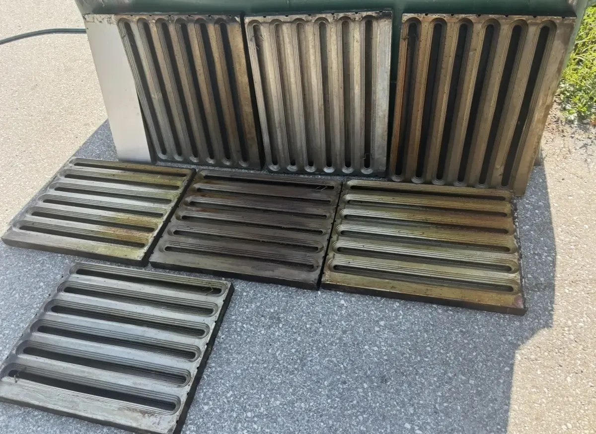 Greasy baffle filters pulled from a kitchen hood, waiting to be degreased